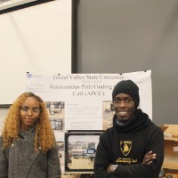 Two students standing next to an EGR 604 project.